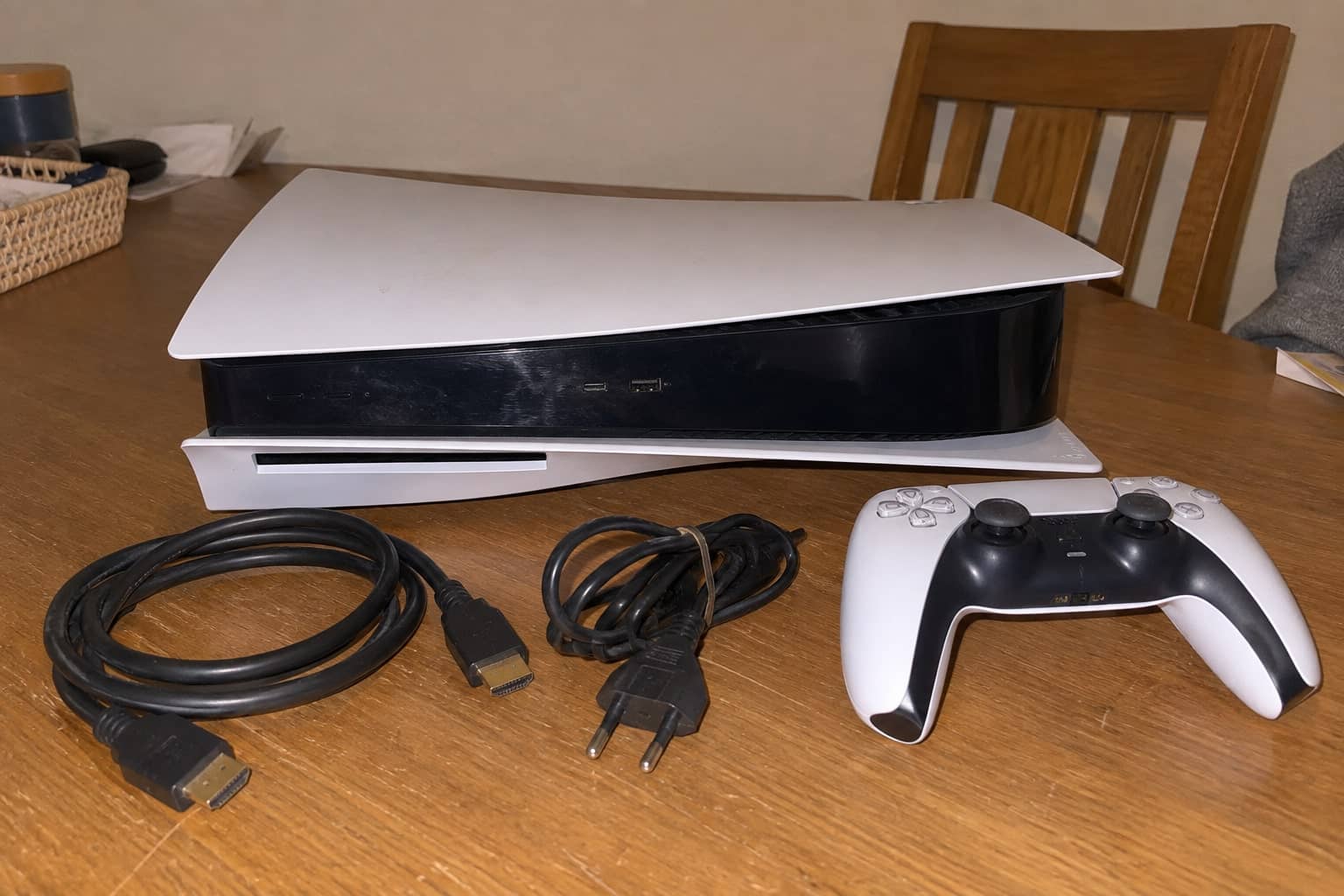 Gebrauchte PS5 mit Controller und Kabeln auf dem Tisch