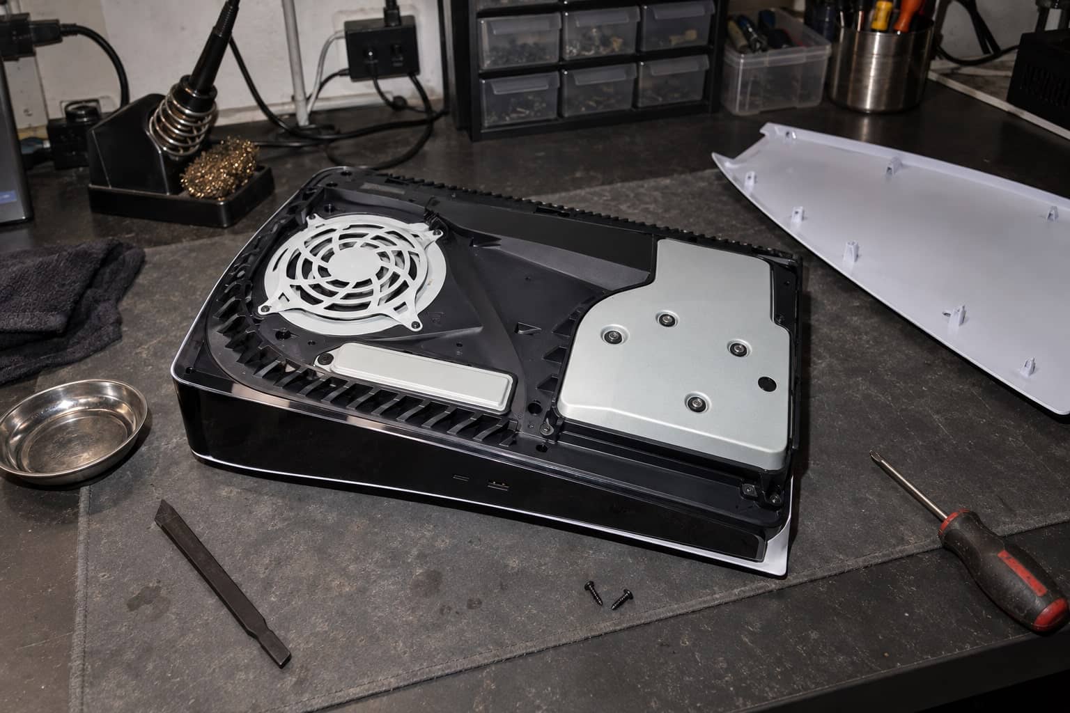 Geöffnete PS5 auf der Werkbank mit Antistatikmatte und Werkzeug